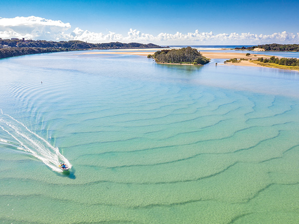 a boat zooming through Nambucca Heads