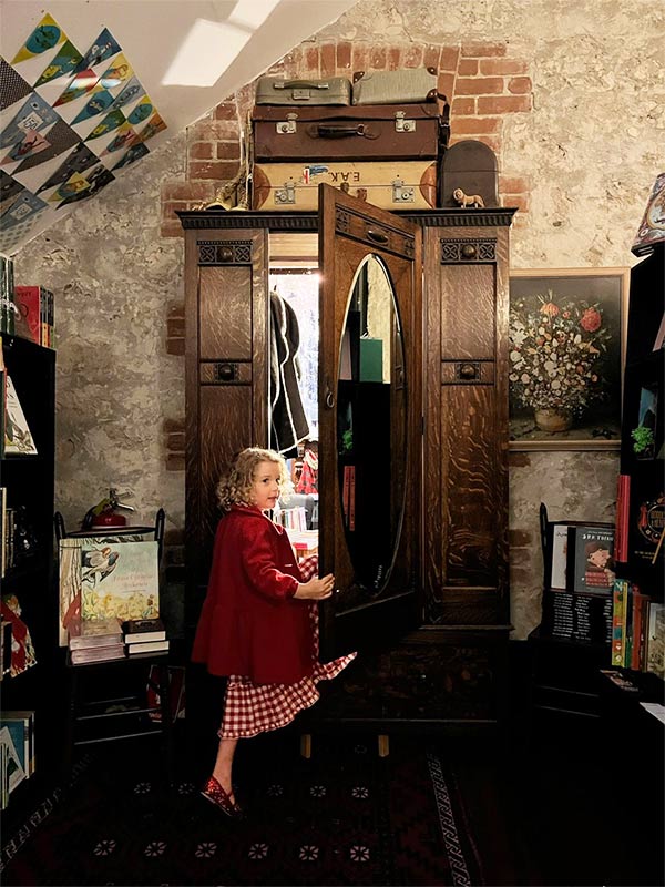 girl walking into narnia wardrobe at Paper Bird book store in fremantle WA