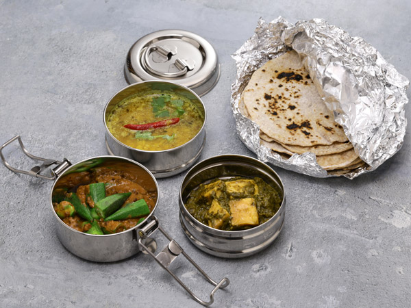 A retro Indian tiffin lunch box filled with vegetarian food. And chapati.