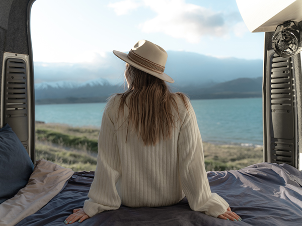 A woman sitting inside Star RV Motorhomes with a view of the lake in the background.