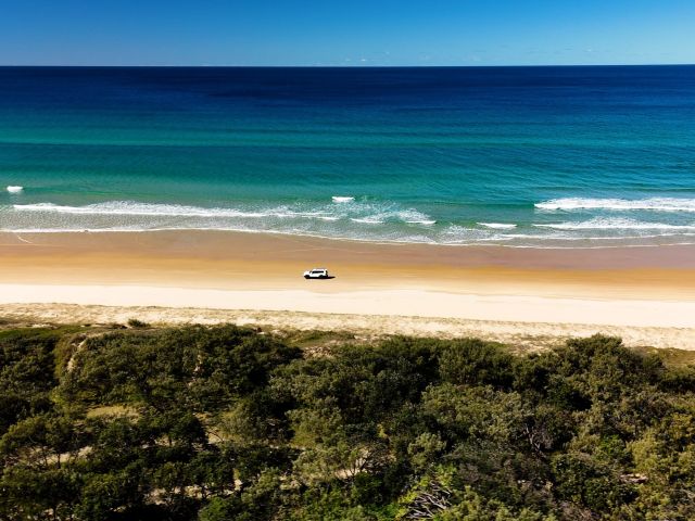 car driving along 75 mile beach on k'gari
