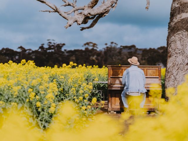 man posing with outdoor piano Cornella Canola Walk