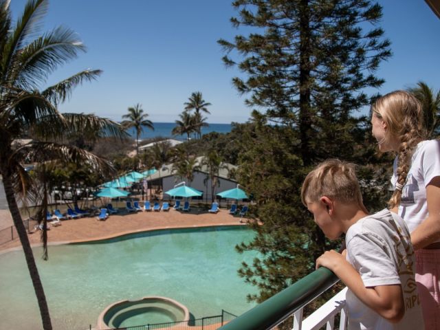 kids looking over hotel room balcony at k'gari beach resort