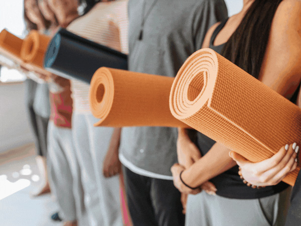 Group of people in exercise class holding yoga mats