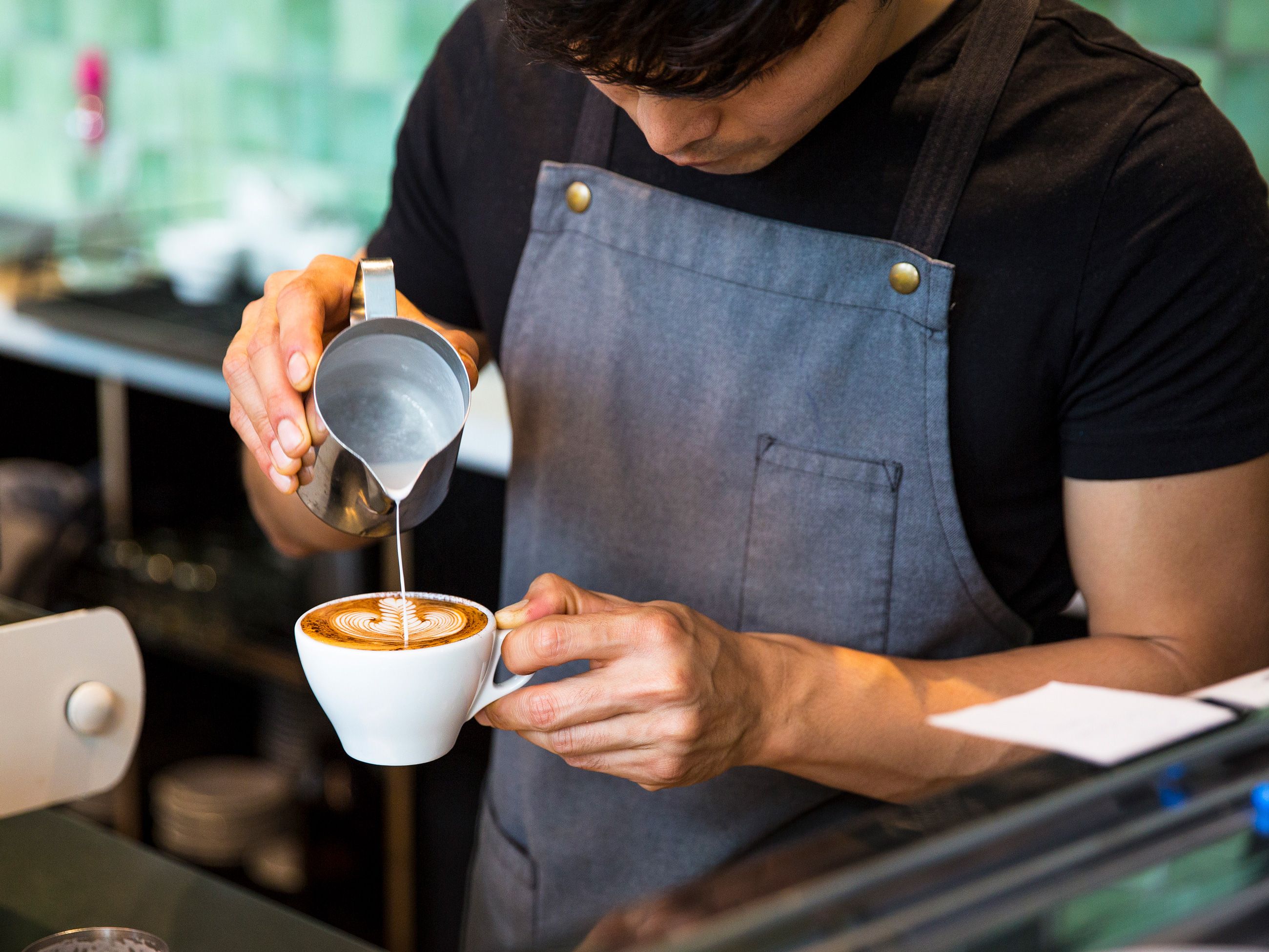 pouring milk over coffee at The Kettle Black, South Melbourne