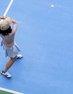 top view of woman playing pickleball, holding paddle to return ball in pickleball court