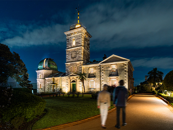 Two people walking to the Sydney Observatory at night