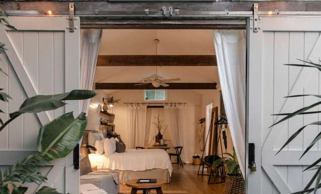 A white barn studio accommodation with barns doors open