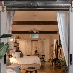 A white barn studio accommodation with barns doors open