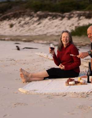 a middle aged couple enjoying a picnic provided by guides of the Maria Island Walk