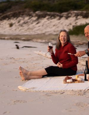 a middle aged couple enjoying a picnic provided by guides of the Maria Island Walk