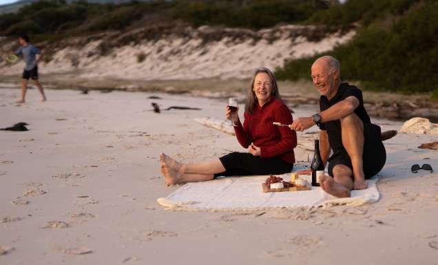 a middle aged couple enjoying a picnic provided by guides of the Maria Island Walk