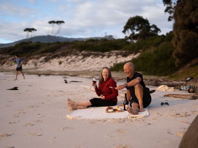 a middle aged couple enjoying a picnic provided by guides of the Maria Island Walk