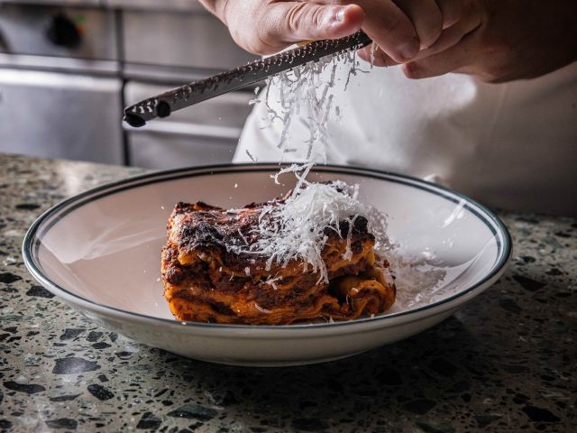 soluna sydney chef grating cheese on lasagna