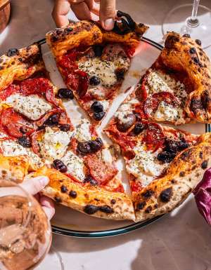 soluna sydney restaurant people eating wood fired pizza and drinking wine