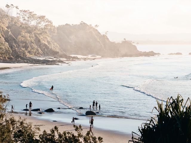 People entering the water at a beach at Byron Bay