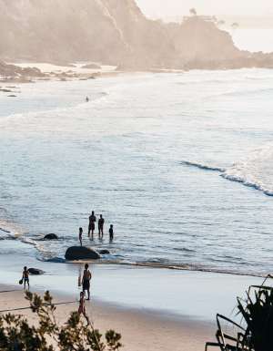 People entering the water at a beach at Byron Bay
