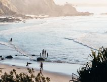 People entering the water at a beach at Byron Bay
