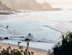 People entering the water at a beach at Byron Bay
