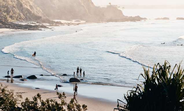 People entering the water at a beach at Byron Bay