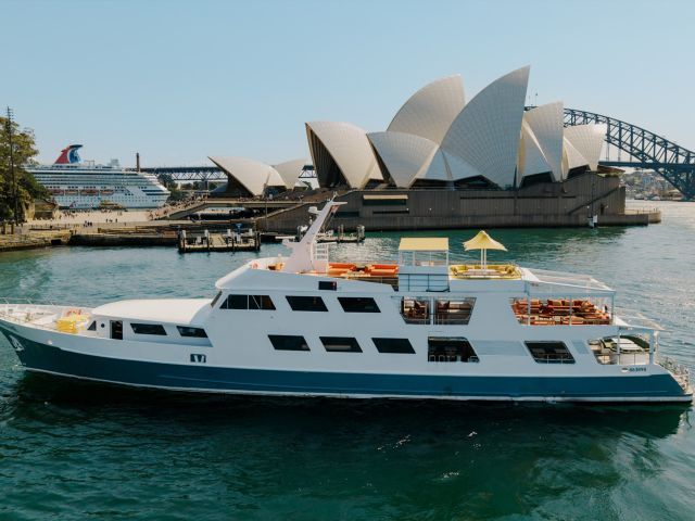 A yacht on Sydney Harbour on a sunny day with the Opera House in the background