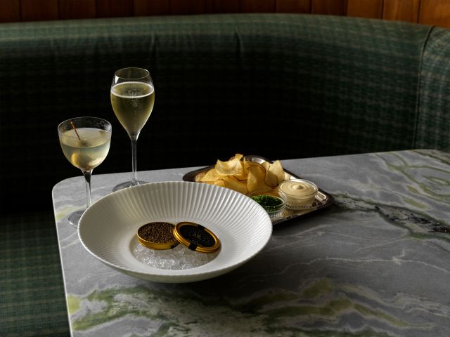 A martini and a glass of bubbles with caviar, crips and crème fraiche