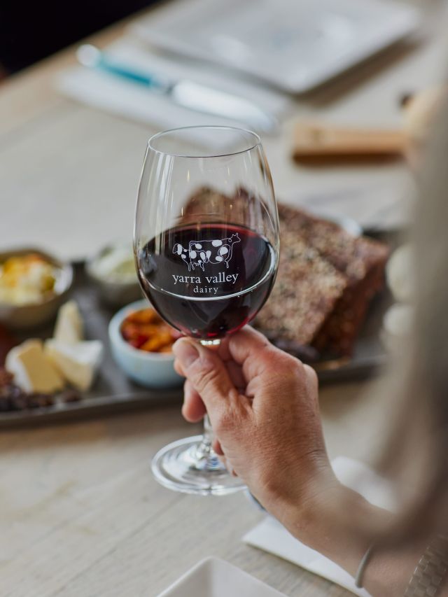 holding a glass of wine at Yarra Valley Dairy