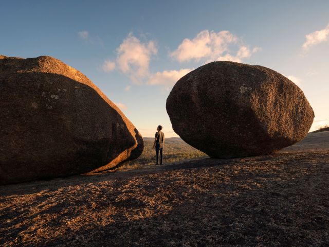 a person standing between boulders in Tenterfield