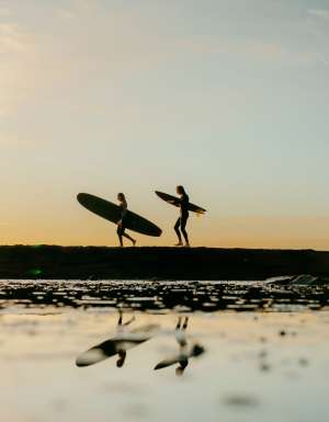 People enjoying a sunset surf at Mollymook, South Coast, NSW