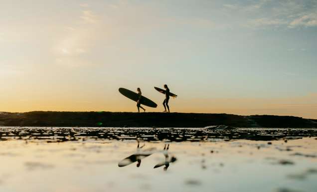 People enjoying a sunset surf at Mollymook, South Coast, NSW