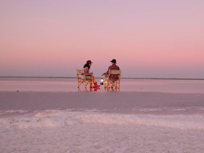 A couple sit on the salt plains of Lake Tyrrell