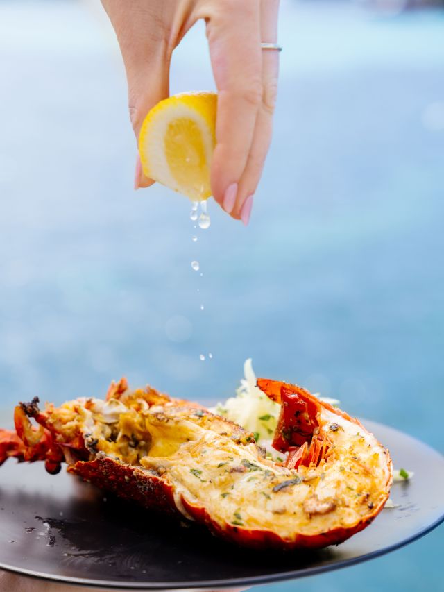 squeezing lemon into a seafood dish at Luxe Island Seafood Cruise with Rottnest Cruises