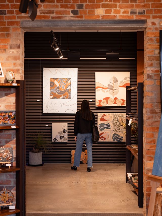 a woman admiring artworks at Perridak Arts Gallery