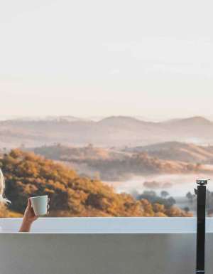 Woman bathes at Sierra Escape with Mudgee views