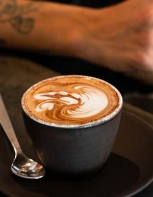 single o surry hills barista leans on bench near coffee