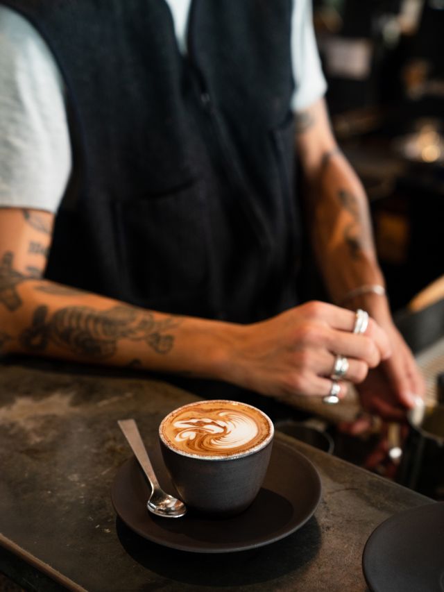 single o surry hills barista leans on bench near coffee
