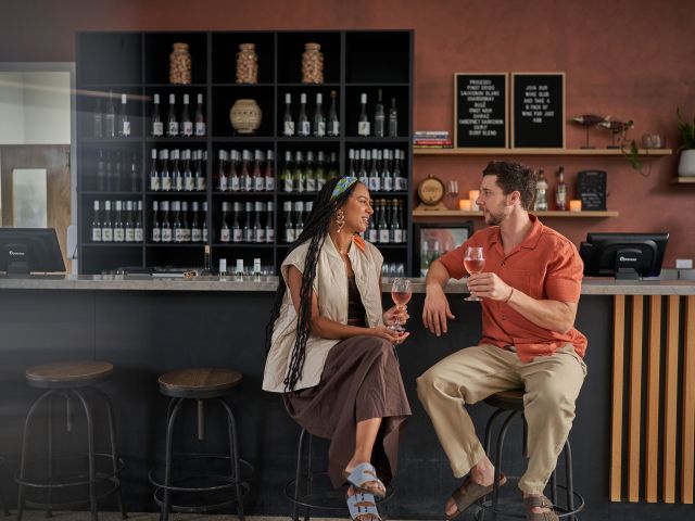 a couple sitting at the bar at squire's winery, sun country on the murray