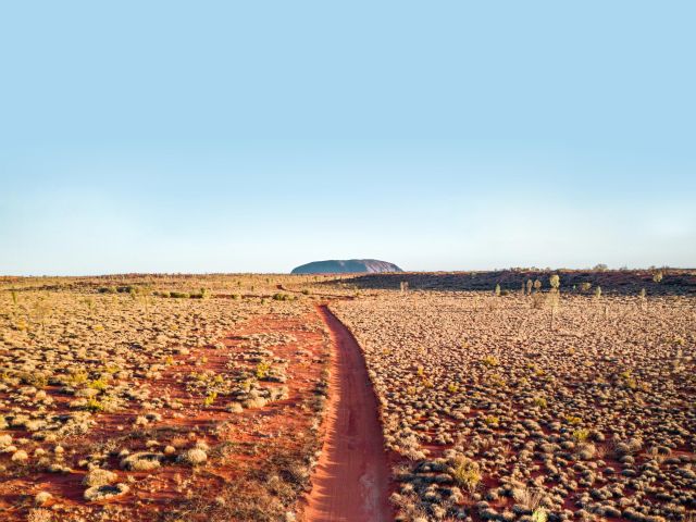 Red dirt landscape in front of Uluru