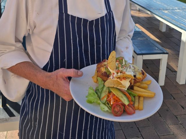 chef holding pub meal at Corindi Beach Hotel