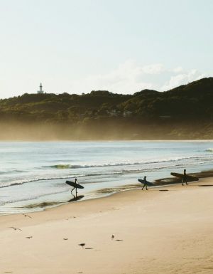 Surfers catching morning waves at Belongil Beach, Byron Bay
