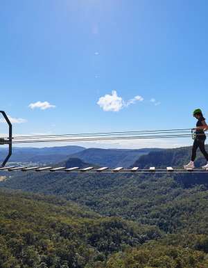 woman walking over Happitat wobbly bridge