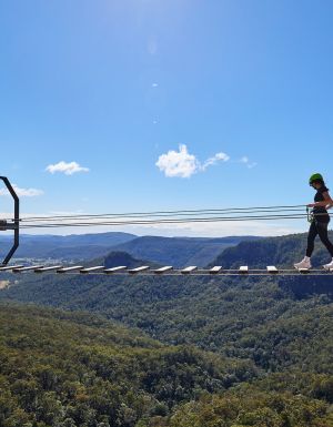 woman walking over Happitat wobbly bridge