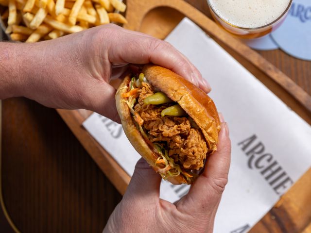 holding a chicken burger at Archies, voco Gosford