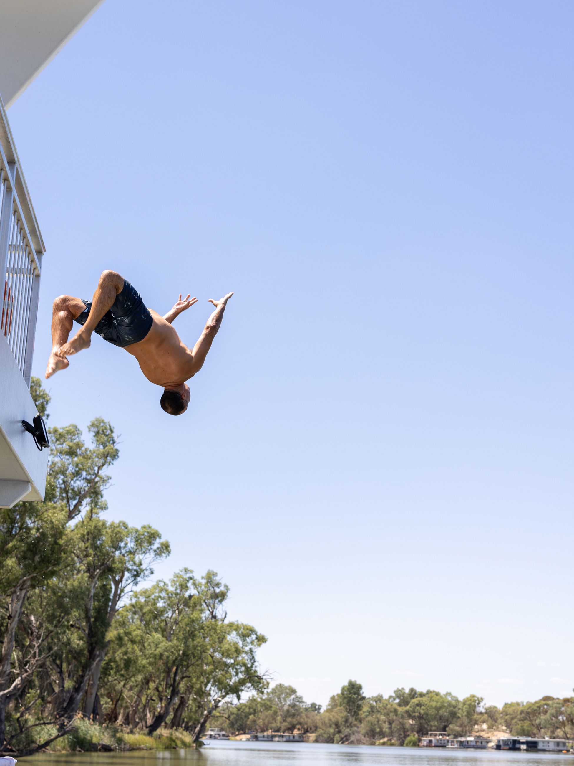 flipping into the water from a high platform of the Murray River houseboat