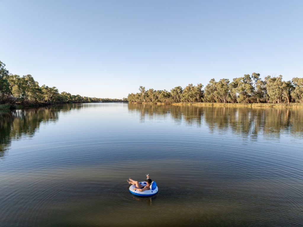 a person relaxing in a water tube on the Murray River