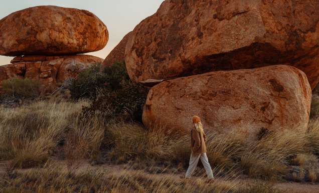 woman walking by Karlu Karlu (Devils Marbles)