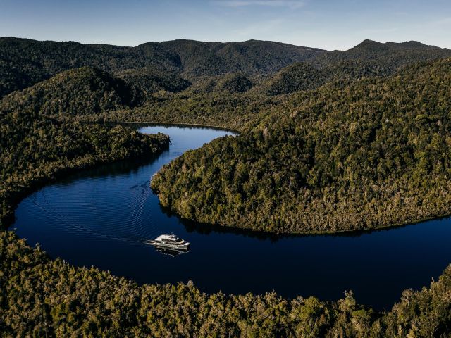 aerial of boat going through strahan tasmania