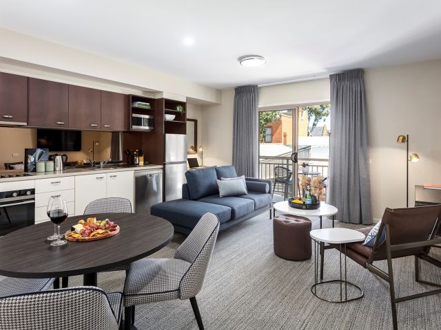 the dining and living room with a balcony at Quest Echuca