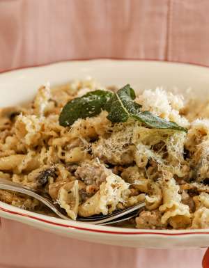 a server at Embr holding a plate of pasta