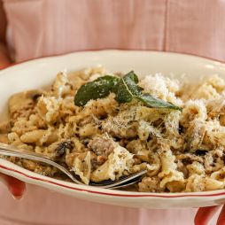 a server at Embr holding a plate of pasta